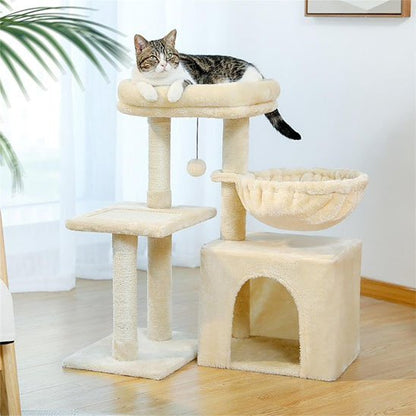 Arbre à chat beige avec niche au sol, hamac suspendu et plateformes où un chat se repose
