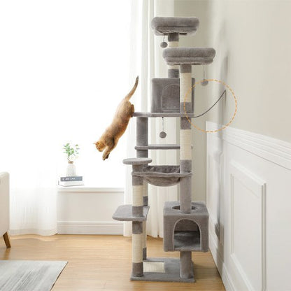 Arbre à chat gris multi niveaux avec plateformes et niche, où un chat saute entre deux niveaux près d’une fenêtre
