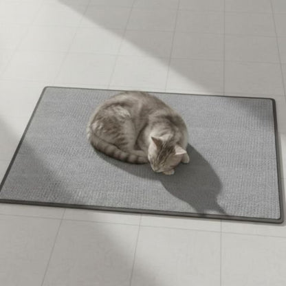 Chat gris recroquevillé sur un tapis griffoir rectangulaire posé sur un sol clair
